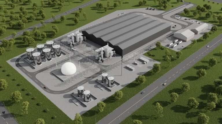 bioaqualife: Aerial view of an industrial plant with large, gray buildings, several cylindrical storage tanks, a white dome structure, surrounding roads, parked vehicles, and green grassy areas with scattered trees.