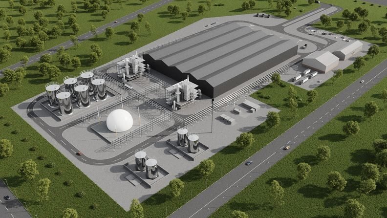 bioaqualife: Aerial view of an industrial plant with large, gray buildings, several cylindrical storage tanks, a white dome structure, surrounding roads, parked vehicles, and green grassy areas with scattered trees.