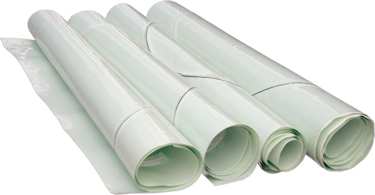 bioaqualife: Four large rolls of white plastic sheeting or vinyl material are placed side by side on a flat surface, partially unrolled, with smooth and shiny surfaces visible.